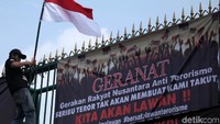 Massa juga mengibarkan bendera merah putih di gerbang gedung DPR.