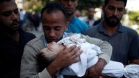 Ayah Leila memeluk jenazah anaknya. REUTERS/Mohammed Salem.
