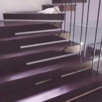 Bagian tangga kayu dengan aksen teralis yang menciptakan suasana modern. Foto: Youtube