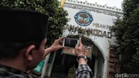 Peziarah memotret makam Mbah Priok.