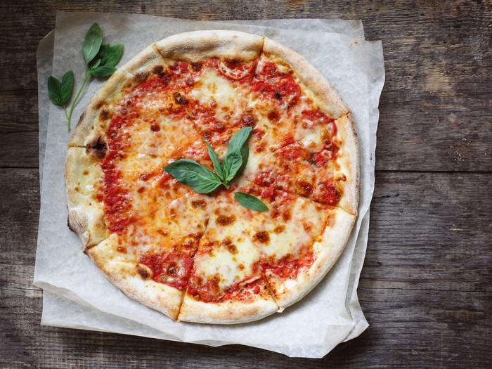 Pizza Domestic classic italian pizza margherita with tomatoes sauce, mozzarella and basil on a table.