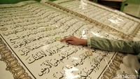 Seorang anak membaca Alquran raksasa yang dipajang di perpustakaan Jakarta Islamic Centre, Jakarta Utara, Kamis (17/5).
