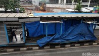 Tampak bagian halte yang rusak ditutup terpal.