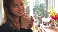 Nggak melulu gaya cool, sesekali Kirana melempar senyum manis saat difoto. Seperti ketika menikmati secangkir kopi ini. Foto: Instagram kiranalarasati