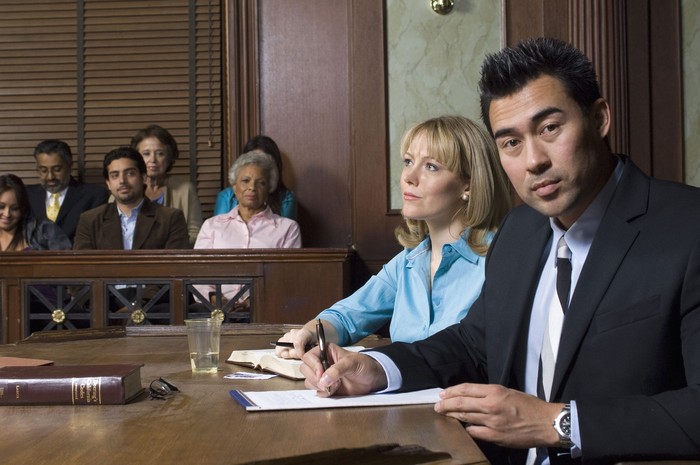 Defense lawyer with client in court