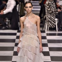 Gaun versi runway juga hadir dengan kerah asimetris, hanya saja berwarna nude dan tak memiliki bagian lengan. Foto: Dok. Getty Images