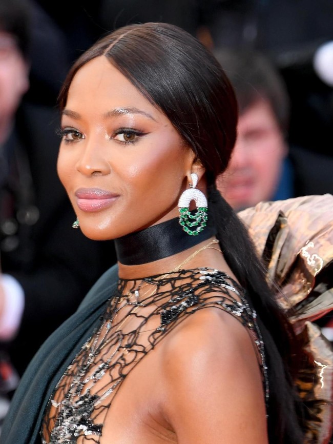 Tidak ketinggalan, anting berlian dengan batu zamrud yang semakin menyempurnakan gaya sang supermodel di era 90an ini. Foto: Getty Images