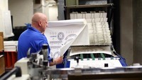 Seorang staff sedang mengawasi proses percetakan desain untuk cangkir edisi khusus Royal Wedding. Jan Kruger/Getty Images.