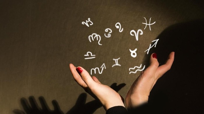 Zodiac signs on touch screen. Woman choosing horoscope symbols.