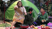 Wah Mbak Nunung lagi piknik nih. Di depan tenda, ia asyik mengipas sate. Sementara makanan di depannya juga ada snack hingga buah segar. Foto: Instagram