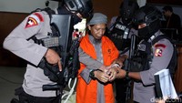 Setelah itu, Aman langsung mengenakan baju tahanan dan tangan diborgol dengan dikawal 3 polisi bersenjata lengkap.