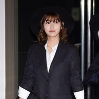Gaya preppy ditunjukkan Hyosung yang memakai jas oversized dan kemeja putih, lengkap dengan topi dan clutch. Tak terlihat juga celana yang dipakainya. Foto: Koreaboo