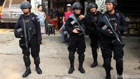 sejumlah polisi berjaga dengan senjata laras panjang.