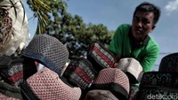 Seorang pedagang berjualan peci atau kopiah di depan Masjid Al Husna, Sungai Bambu, Jakarta Utara, Jumat (18/5/2018).