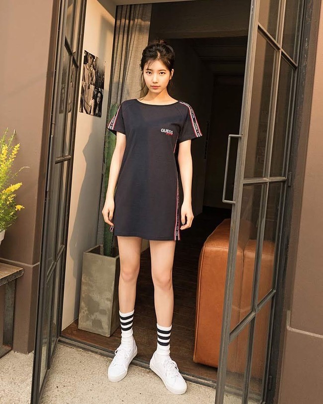 Pemotretan untuk iklan Guess, Suzy tampil sporty dengan T-shirt dress yang dipadu kaos kaki dan sneakers putih. Foto: Koreaboo