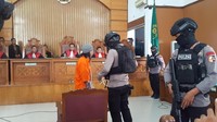 Aparat Kepolisian bersenjata lengkap mengantar Aman sampai di kursi terdakwa dan mulai melepaskan borgolnya (Foto: Zunita Amalia Putri/detikcom)