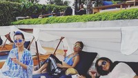 Asyiknya, santai bareng di pinggir pantai sambil menikmati segelas wine. Btw, itu ada anak siapa yang tetap pulas tidur? Foto: instagram @melissa_karim