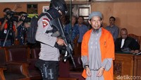 Aman tiba di PN Selatan dengan didampingi oleh sejumlah polisi bersenjata lengkap laras panjang. 