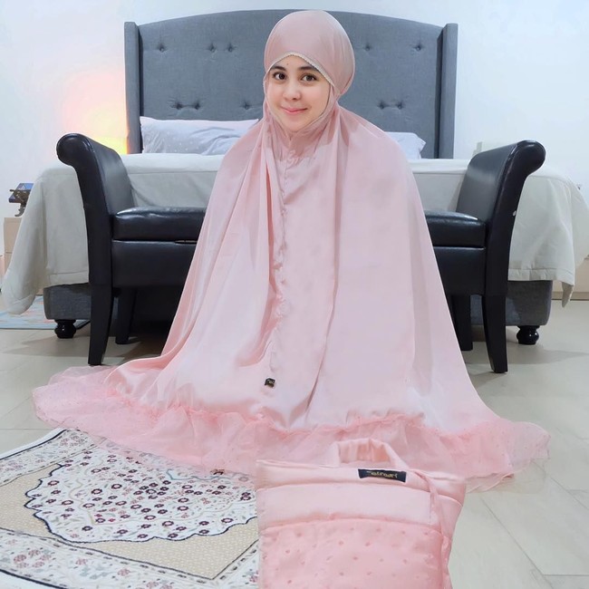 Risty Tagor memilih mukena bernuansa merah muda dengan aksen renda untuk Ramadan tahun ini. Mukena berbahan satin itu tampak mewah dipadukan dengan renda berbahan organza. Foto: Instagram