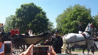 Warga bersorak sambil meneriakkan nama Harry dan Meghan. Mereka mengibarkan bendera. Di antara mereka juga ada yang mengabadikan momen tersebut menggunakan ponsel.