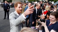 Memakai kemeja putih dan jas, Harry sempat mengobrol dengan beberapa warga. Foto: REUTERS/Damir Sagolj