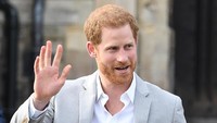 Pangeran Harry menemui warga dan para fans di Windsor sehari jelang pernikahannya dengan Meghan Markle. Harry pun sempat mengambil suvenir dari fansnya. Foto: REUTERS/Toby Melville