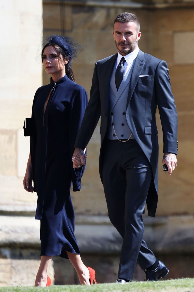 Victoria Beckham mencuri atensi dengan midi-dress biru navy berpotongan  minimalis yang diyakini sebagai busana rancangannya sendiri. Gaun tersebut hadir dengan detail key-hole yang mengekspos sedikit area dadanya. Foto: Getty Images