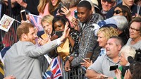 Warga riuh dan berebut bertanya ke Pangeran Harry. Dia kemudian membawa boneka itu ke dalam kastil. Foto: REUTERS/Toby Melville