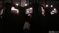 Seorang pengunjung tampak serius melihat dan membaca keterangan foto.