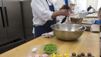 Chef Stoby mengisi setiap cangkang cokelat dengan saus cokelat khusus, yang telah dilelehkan hingga lembut ke dalam mangkuk besar lalu dicampur dengan truffle. Foto: Royal UK