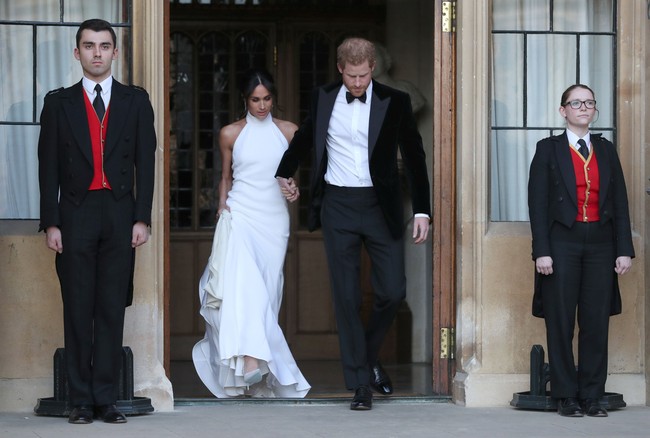 Pesona Meghan Markle kian terpancar dalam balutan gaun high neck putih berpotongan mermaid rancangan Stella McCartney. Sementara Pangeran Harry tampil gagah dengan jas beludru hitam dan dasi kupu-kupu. Foto: Reuters