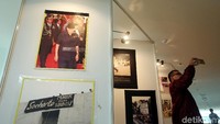 Pengunjung selfie di depan jajaran foto yang dipamerkan.