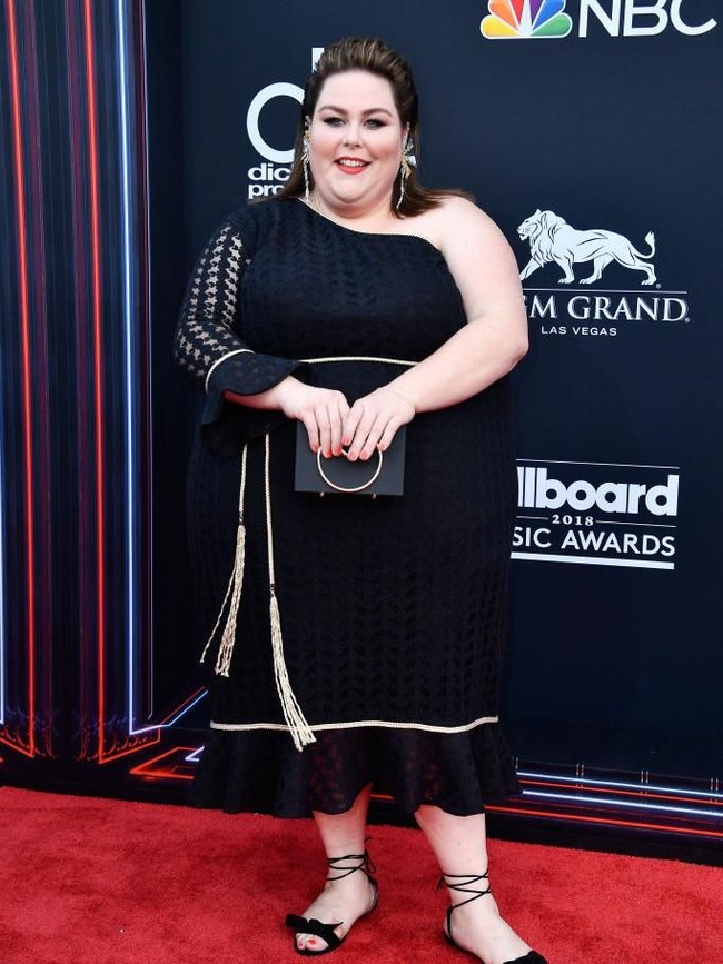Berbekal rasa percaya diri, bintang This Is Us Chrissy Metz memukau dengan gaun hitam bergaris leher asimetris yang mengekspos bahunya. (Foto: Getty Images)