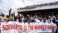 Para demonstran juga mengkritik kebijakan ekonomi Soeharto yang dianggap terlalu terbuka dengan negara asing dan isu Korupsi, Kolusi, dan Nepotisme (KKN) yang santer diberitakan marak terjadi di keluarga dan orang terdekat Soeharto. Patrick Aventurier/via Getty Images.