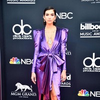 Dua Lipa mencuri perhatian dengan gaun ungu metalik yang berpotongan klasik. Unik namun tak berlebihan. (Foto: Getty Images)