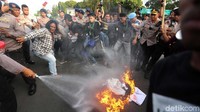 Polisi pun berusaha memadamkan akis bakar ban tersebut.