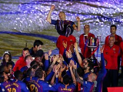 Momen saat Iniesta dilempar ke udara oleh rekan-rekannya di Barca. Foto: Albert Gea/Reuters