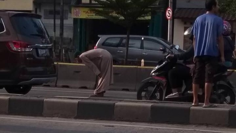 Diklakson Truk, Pria Bergamis yang Salat di Tengah Jalan Bergeming Diklakson Truk, Pria Bergamis yang Salat di Tengah Jalan Bergeming