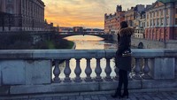 Amine juga pernah liburan ke Stockholm. Di sana ia sempat menatap senja dengan latar bangunan bersejarah (@gulseamine/Instagram)