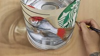 Wow! Ada air dan seekor ikan di gelas plastik Starbucks. Tentunya ini bukan sungguhan, tapi hanya sebuah gambar. Karyanya ini tetap sama dengan yang lainnya, yaitu dibuat di atas papan plywood. Foto: Instagram @ivanhooart