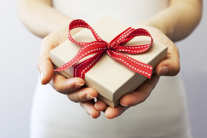 ilustrasi kado A person holding a gift box.