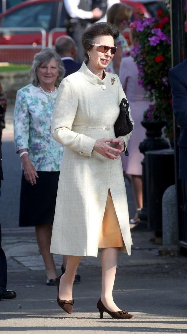 Bangsawan 67 tahun itu tampil elegan dalam balutan blus krem berpotongan coat dan rok coklat dengan bros emas sebagai sentuhan akhir. Turut menyempurnakan gayanya, clutch hitam dan velvet heels coklat dengan aksen pita yang manis. Tidak ketinggalan, kalung dan anting mutiara. (Foto: Getty Images)