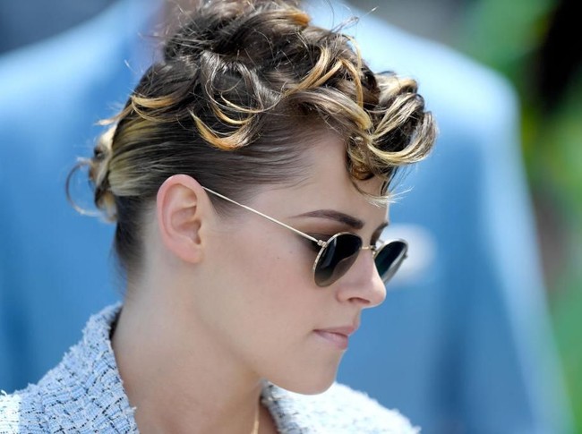 Busananya yang bernuansa feminin dikontraskan dengan gaya rambut Kristen yang unik. (Foto: Getty Images)