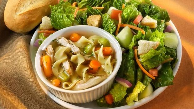 Cup of chunky chicken noodle soup and fresh green salad.  Healthy Lunch or dinner.Shot with a Nikon.