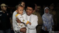 Menteri Sosial Idrus Marham menggendong anak korban kebakaran Cipinang Muara dan Duren Sawit di Banjir Kanal Timur, Jakarta Timur, Selasa (22/5/2018).
