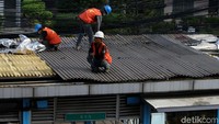 Petugas bahu-membahu menyelesaikan pembongkaran halte.