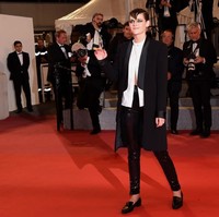 Jelang hari terakhir Festival Film Cannes, Kristen Stewart memukau dengan gaya androgyny dalam balutan tuksedo Chanel. Dalaman berupa blouse putih dibiarkan terbuka setengah sehingga memamerkan perut ratanya. (Foto: Getty Images)