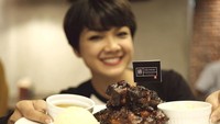 Jangan salah fokus! Ini pose Nirina yang sedang memegang iga panggang nikmat di depannya. Foto: Instagram nirinazubir_