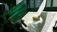 Ada dua orang di sebelah kanan dan kiri yang akan membantu untuk membuka lembaran Alquran. Ardian Fanani/detikcom.