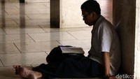 Ada yang membaca alquran di halaman masjid.